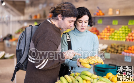 European couple standing near banana counter