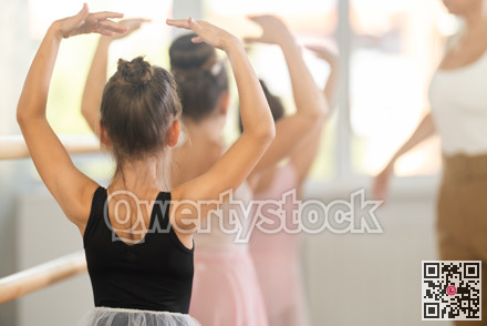 Little ballerinas learn to get into fourth position in ballet class. Choreographer helps them with this