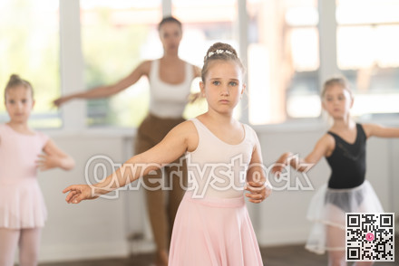 Ballet lesson for children - choreographer teaches girls ballet steps in studio