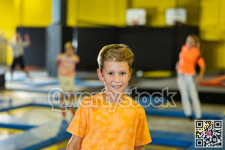 Portrait of happy boy against the background of playing children in an amusement park