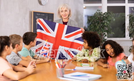 Female teacher showing british flag to kids in geography class