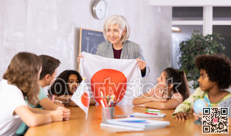 Female teacher showing japanese flag to kids in geography class