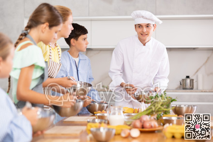 Group of teenagers and friendly chef cook cooking in modern kitchen. Learn to beat raw eggs