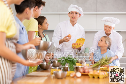 During cooking lesson, male cook tells children about culinary rules, woman assistant helps child