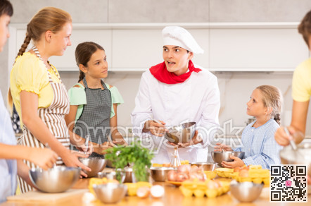 In cooking class, guy cook with bowl in hands tells children participants culinary ticks and tricks