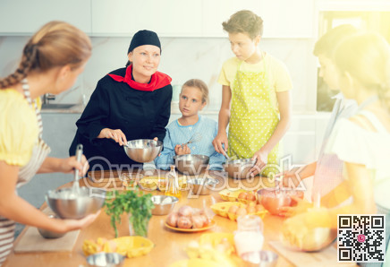 At cooking course, woman cook in black suit tells children about rules of cooking fluffy pancakes.