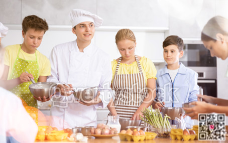 In cooking class, guy cook with bowl in hands tells children participants culinary ticks and tricks