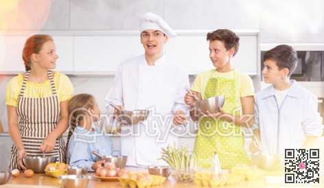 Cooking class, culinary, food and people concept - happy group of children and male chef cook cooking in modern kitchen