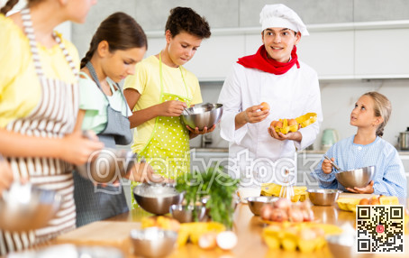 Cooking class, culinary, food and people concept - happy group of children and male chef cook cooking in modern kitchen