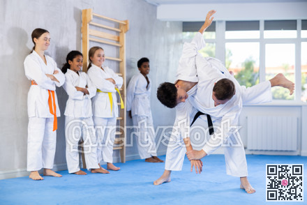 Martial arts master demonstrating throwing technique in sparring with teenager