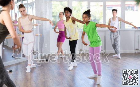 Group of teenage dancers training ballet in studio