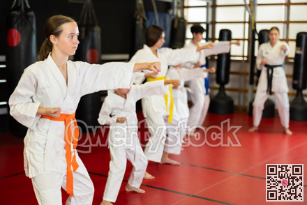 Children students repeat position and perform sequence of punches and painful techniques kata