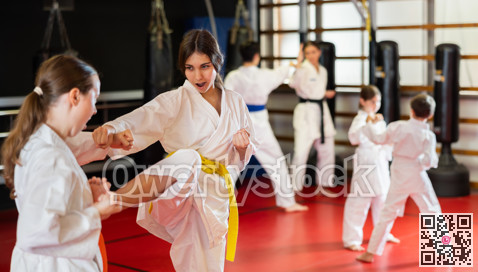 Teen girls athletes in pair conduct training battle in oriental fighting technique