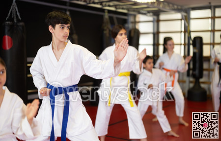 Group of children and teenagers practice karate
