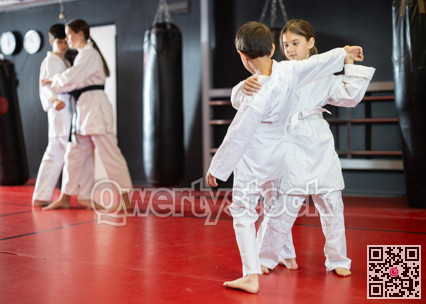 Children athletes in pair conduct training battle in oriental fighting technique