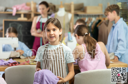 Positive girl child in study room of sewing school and young designers
