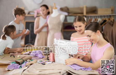 Girl child watches female classmates sew and creating clothes