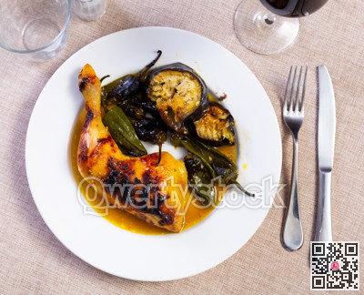 Chicken thigh with stewed eggplant on a ceramic plate cooked in cafe