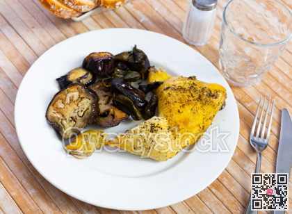 Chicken thigh with stewed eggplant on a ceramic plate cooked in cafe
