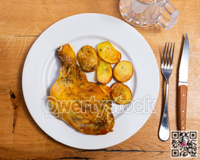 Chicken thigh served with potatoes on dinner plate