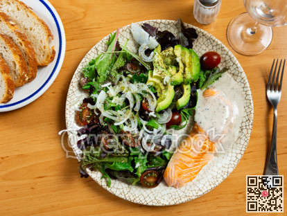 Colorful vegetable salad and grilled salmon on beige background of wooden table or tablecloth
