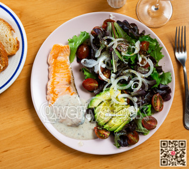 Baked salmon fillet served with avocado salad