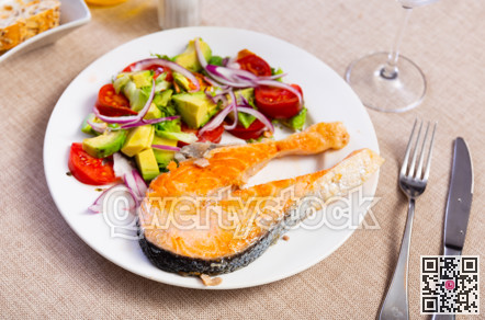 Baked salmon fillet served with avocado salad
