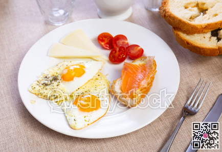 Salted salmon, fried eggs, cheese and ripe tomatoes - delicious breakfast