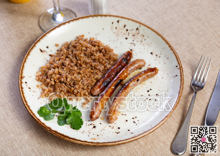 Fried sausages served with buckwheat groats