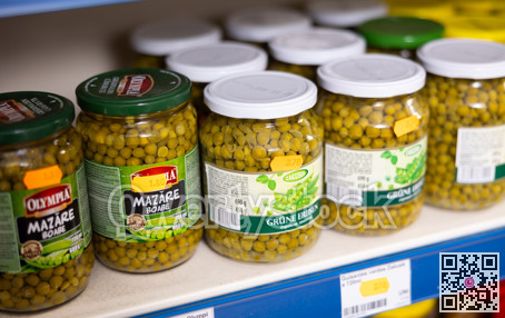 BADALONA, SPAIN - February 12, 2024: Glass jars with canned green peas on shelves of a Russian grocery store in Spain. Traditional Russian appetizer