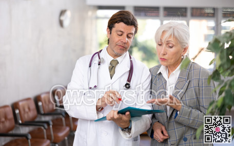 Adult male doctor and elderly woman with documents folder