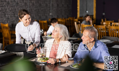 Female hostess serves puts on table order for elderly spouses