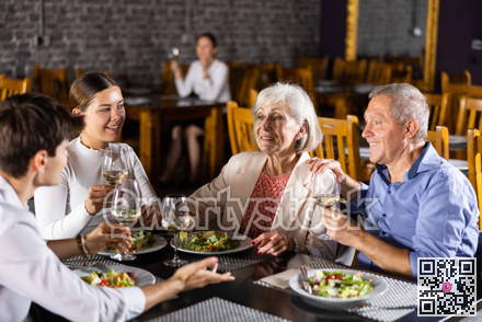 Happy senior couple meeting with adult children in restaurant