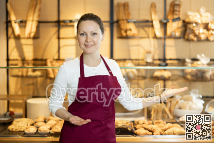 Female baker confidently welcoming customers into her bakery