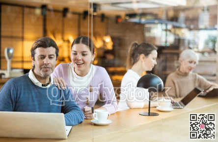 Confident male and female cafe customer enjoying coffee while working on laptop