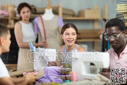 Young woman stitching at machine during sewing class for adults
