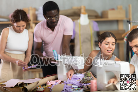 Two students working with textile and others sewing