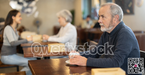 Elderly man with hot cup of coffee in hands
