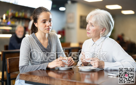 Young and elderly woman drinking coffee in cafe