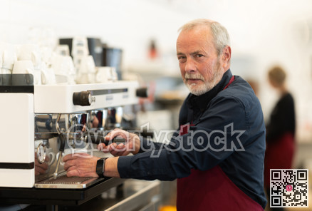 Elderly cafe seller prepares delicious coffee in coffee machine