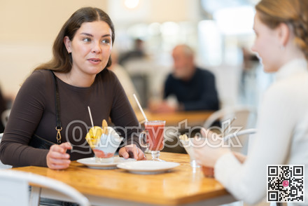 Young woman with teen girl chatting and gossip while drink latte coffee, eating ice cream