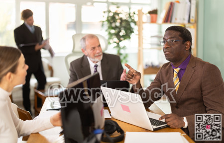 Businessmen use laptops during a conference in meeting room with colleagues