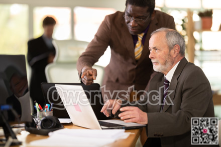 African businessman helps an employee with a program on a laptop