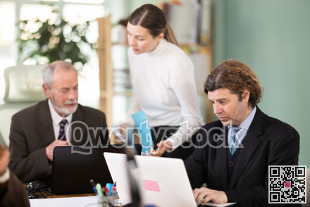 European man working on laptop with room in office