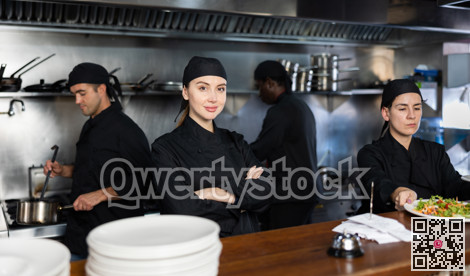 Woman executive chef posing in restaurant kitchen