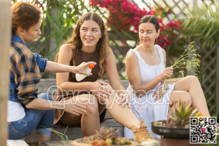 Women spray mosquito repellent on their legs and arms while working in farm and garden
