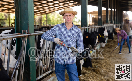 Male farmer standing with syringe at farm