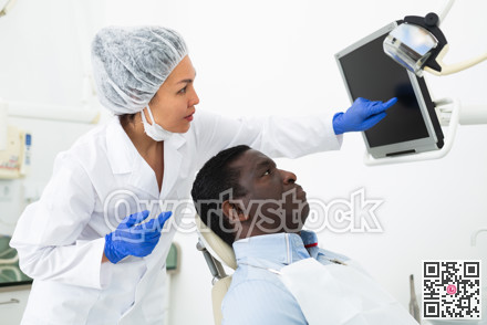 Doctor dentist shows the patient the result of dental x-ray