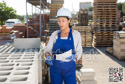 Asian woman worker keeps records of bricks