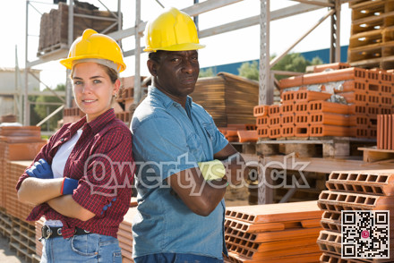 Workers in hardhats standing in construction material storage
